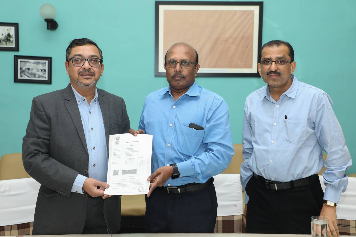 Col. (Retd.) S.D. Aravendan (centre), Chief Administrative Officer, IIMB, and Mr. Shoubhik Dasgupta (left), COO, Pi EV Solutions Pvt Ltd., an electric vehicle charging solutions provider, exchange an agreement for the installation of an EV charging station for two-wheelers and four-wheelers on campus. Mr. Vasudeva M, Chief Manager, Infrastructure at IIMB, looks on.