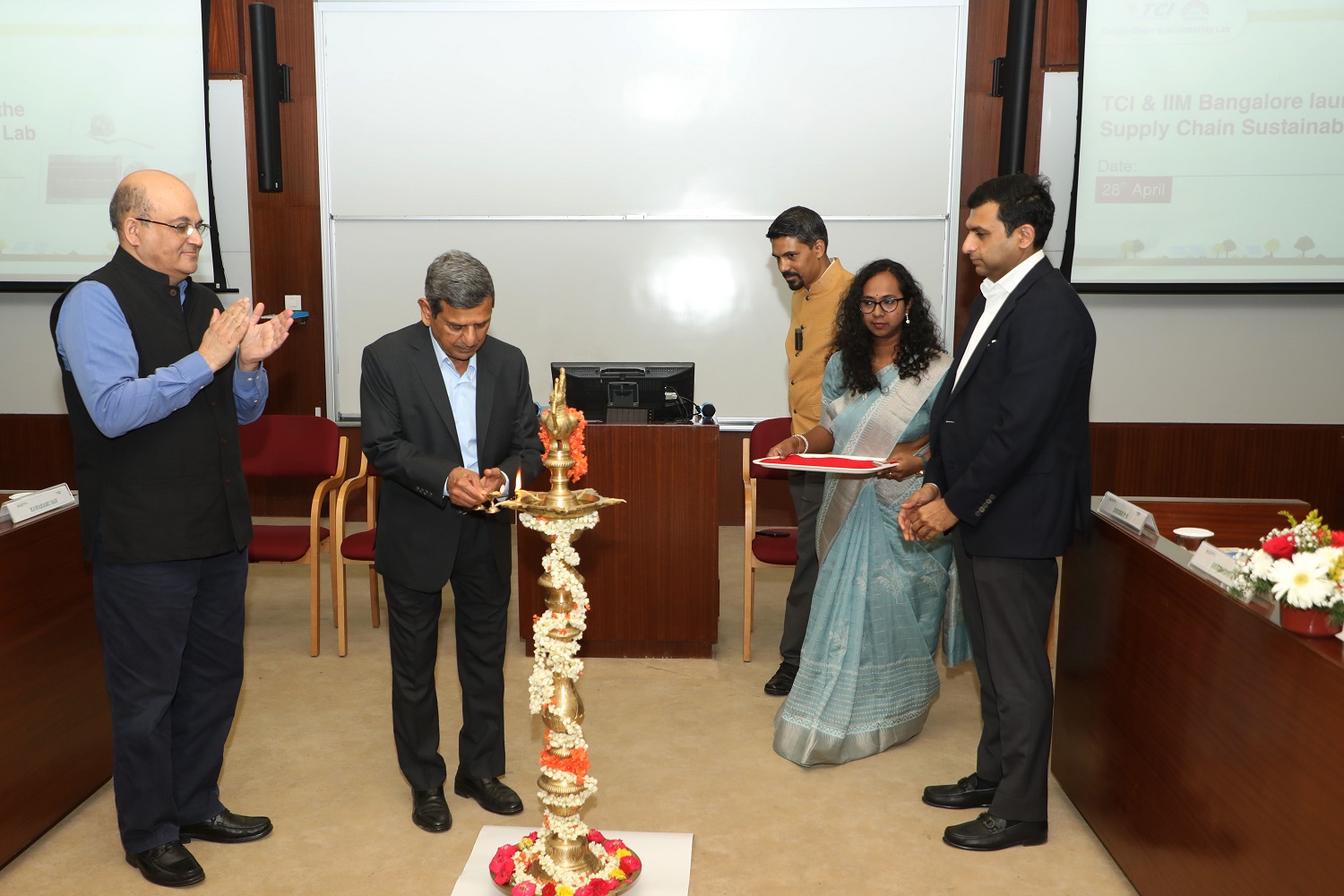Shri DP Agarwal, Chairman, TCI Group, lights the lamp at the inauguration of the TCI-IIMB Supply Chain Sustainability Lab on 28th April 2023. Prof. Rishikesha T Krishnan, Director, IIMB, Prof. Jitamitra Desai, Chairperson, Supply Chain Management Centre, IIMB, Vineet Agarwal, MD, TCI Group, looks on.