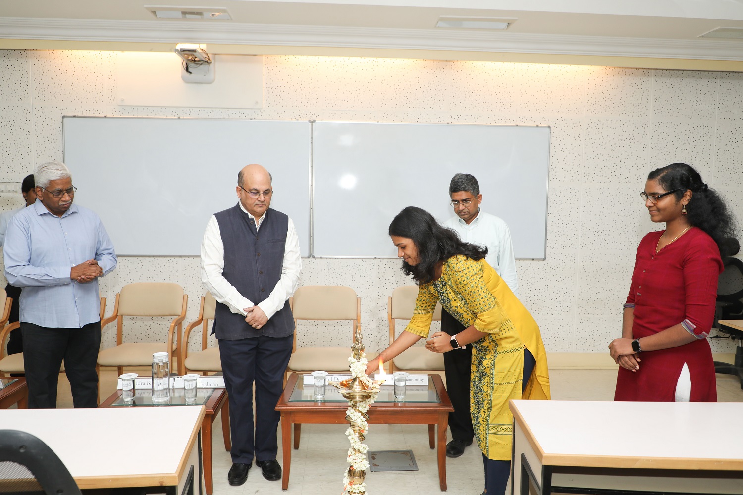 A student lights the ceremonial lamp at the inauguration of the new batch of the Doctoral Programme (PhD) of the institute, on 12th June 2023. Prof. Rajendra K Bandi, Dean, Administration and faculty in the Information Systems area, Prof. Rishikesha T Krishnan, Director, IIM Bangalore and Prof. Ananth Krishnamurthy, Chairperson, PhD programme and faculty in the Decision Sciences area, look on.